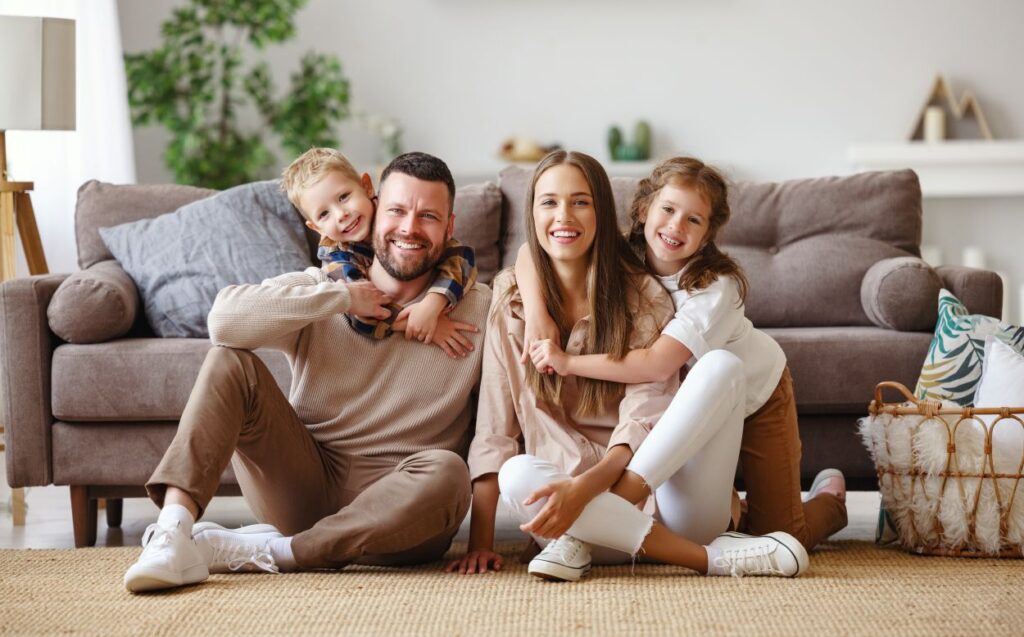 happy family mother father and children at home on couch