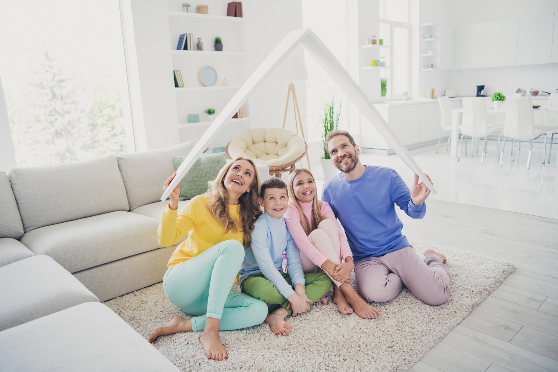 Happy Family with pretend roof overheads sitting on floor in living room