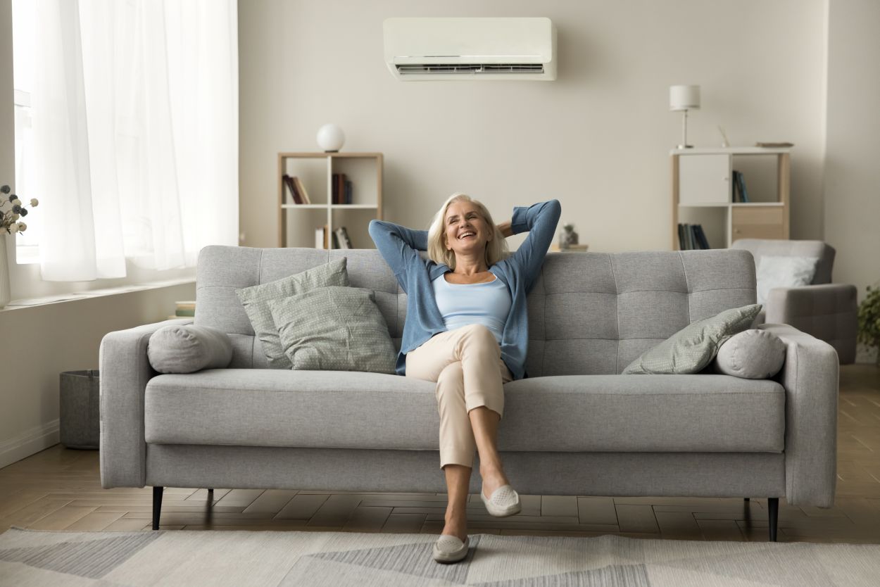 woman comfortable on sofa with working AC wall unit